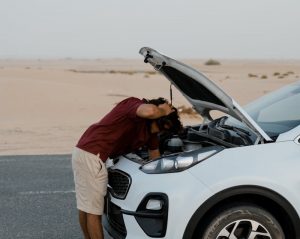 a man looking at his car's engine